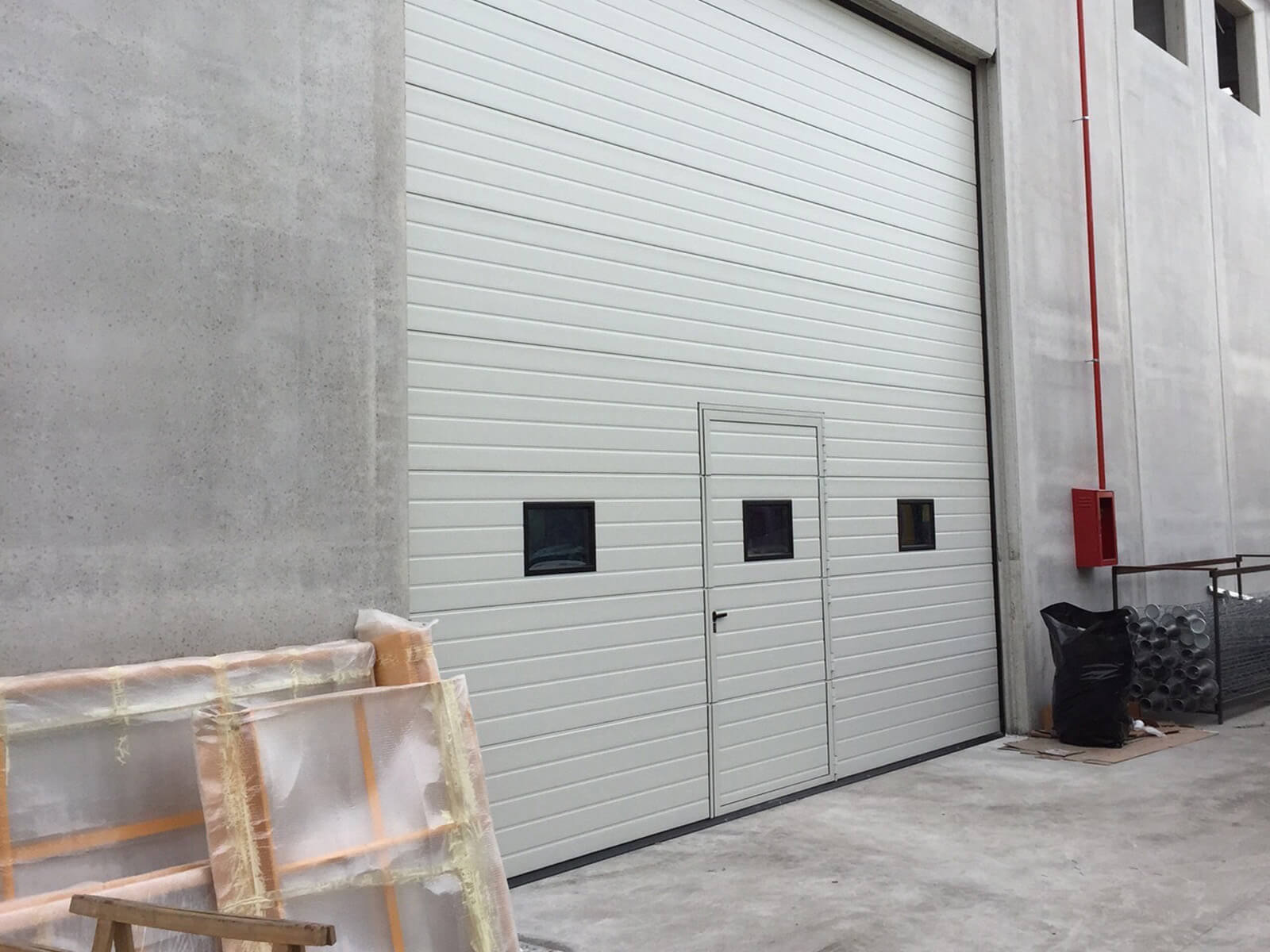 Portone sezionale industriale SECURA - Stucco bianco C21 porta pedonale ribassata