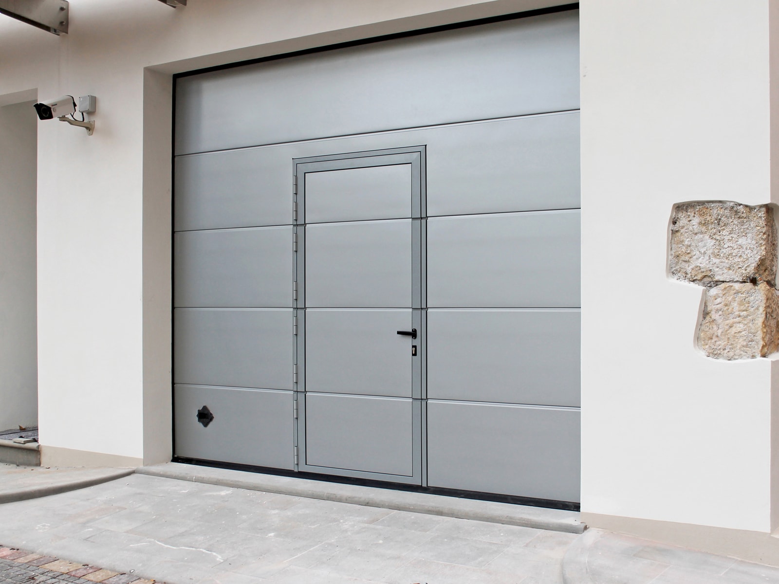 Portone sezionale da garage PERSUS - Liscio grigio 9006 porta pedonale ribassata